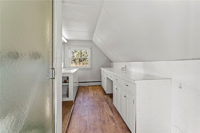 bonus room with lofted ceiling, baseboard heating, and dark wood-type flooring