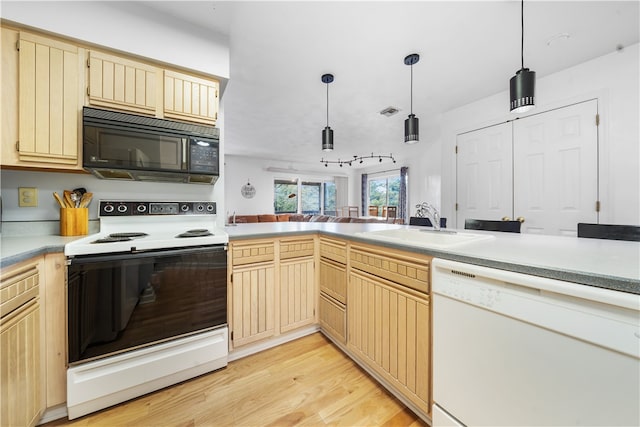 kitchen featuring light brown cabinets, light wood-type flooring, sink, decorative light fixtures, and white appliances