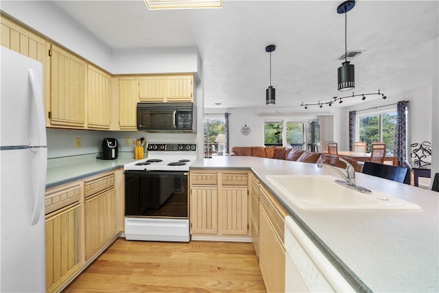 kitchen with white appliances, light brown cabinetry, sink, light wood-type flooring, and hanging light fixtures