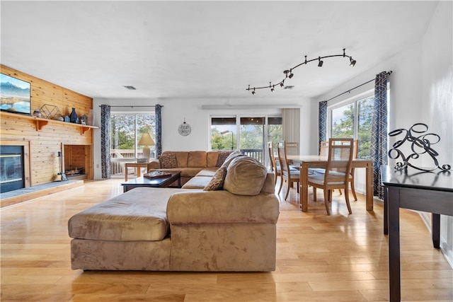 living room with light wood-type flooring and wood walls