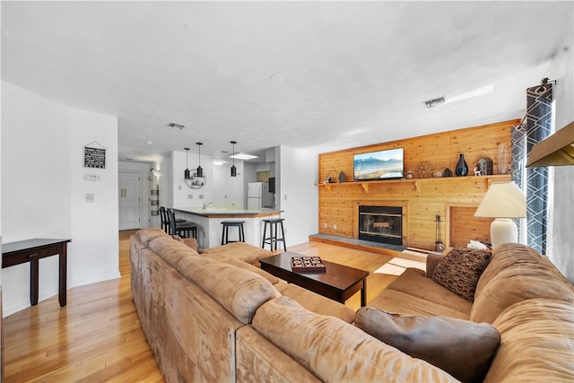 living room with wooden walls and light wood-type flooring