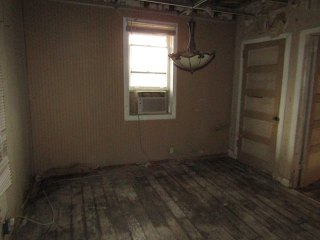 unfurnished room featuring cooling unit and hardwood / wood-style flooring