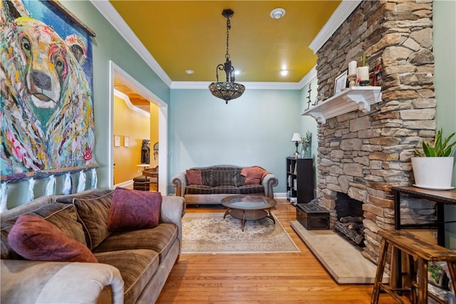 living room with a fireplace, crown molding, and wood finished floors