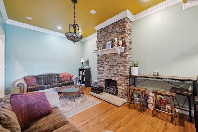 living room featuring ornamental molding, a stone fireplace, and wood finished floors