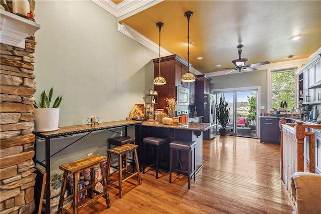 bar featuring pendant lighting, crown molding, stainless steel appliances, light wood-style floors, and ceiling fan