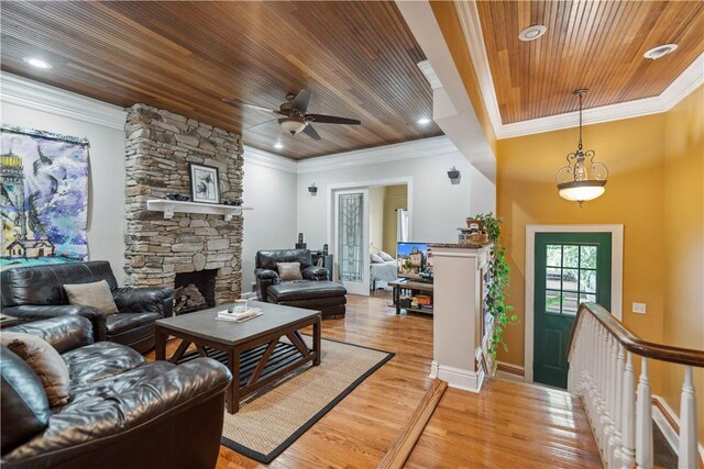 living room with ceiling fan, wooden ceiling, light hardwood / wood-style flooring, a fireplace, and ornamental molding