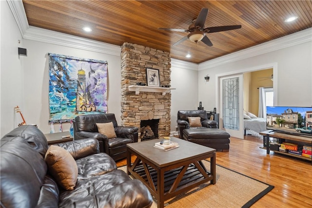 living room featuring light wood-type flooring, wood ceiling, crown molding, and a stone fireplace