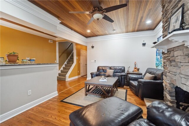 living room featuring light hardwood / wood-style flooring, ceiling fan, wooden ceiling, and crown molding