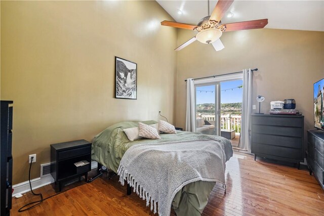 bedroom with ceiling fan, access to exterior, wood-type flooring, and high vaulted ceiling