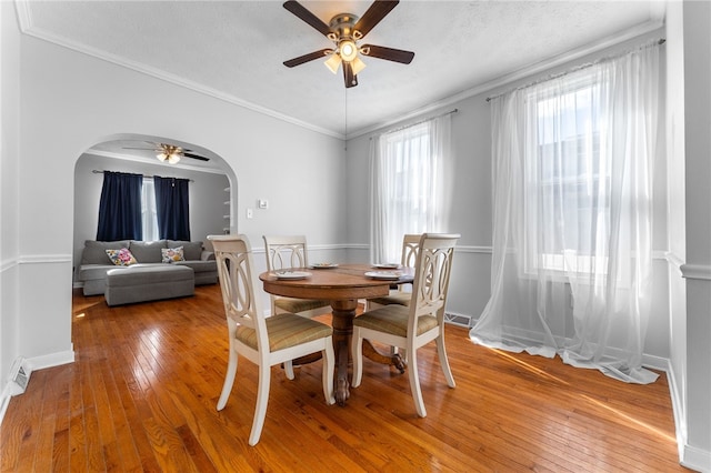 dining space with ornamental molding, hardwood / wood-style floors, a textured ceiling, and ceiling fan