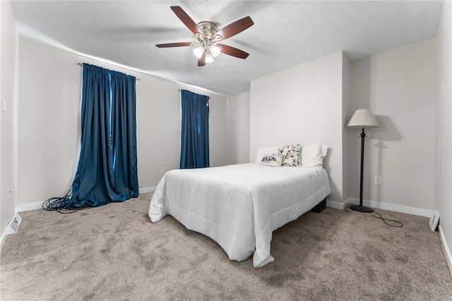 carpeted bedroom featuring a textured ceiling and ceiling fan