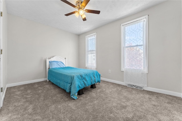 carpeted bedroom featuring a textured ceiling and ceiling fan