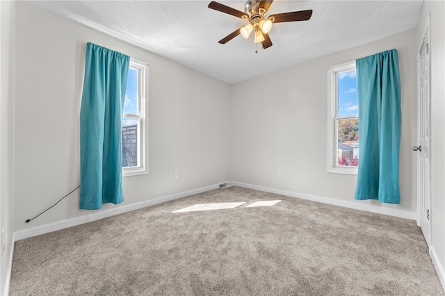 empty room featuring ceiling fan, a textured ceiling, and carpet floors