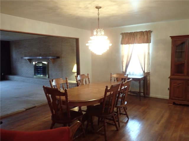 dining area with dark hardwood / wood-style floors, a chandelier, and a fireplace