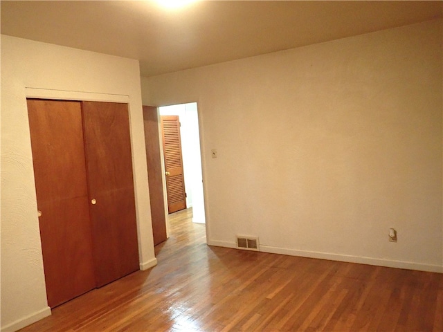 unfurnished bedroom with a closet and wood-type flooring