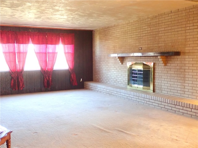 unfurnished living room with carpet floors and brick wall