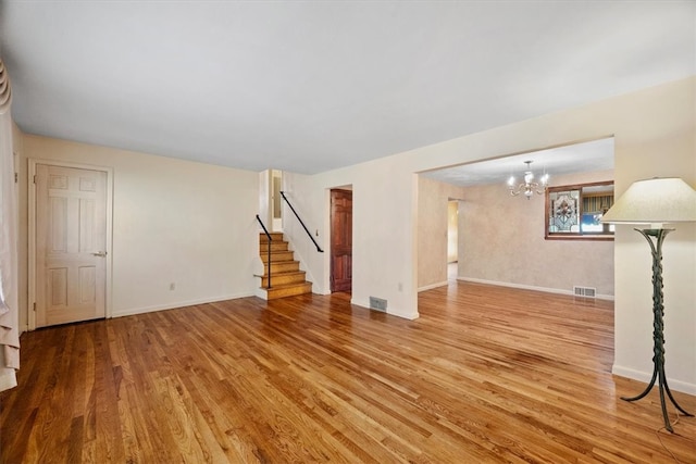 unfurnished living room with hardwood / wood-style floors and a chandelier