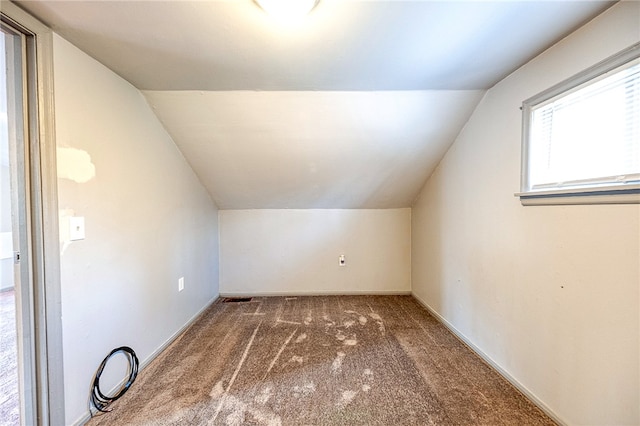 bonus room featuring vaulted ceiling and dark carpet