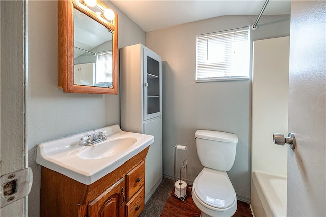 bathroom with vanity, toilet, and lofted ceiling