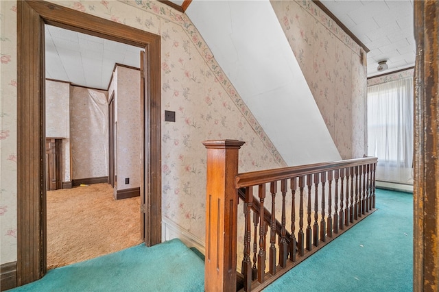 hallway featuring lofted ceiling, baseboard heating, and carpet