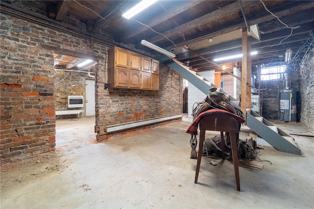 basement with brick wall, a baseboard radiator, and water heater