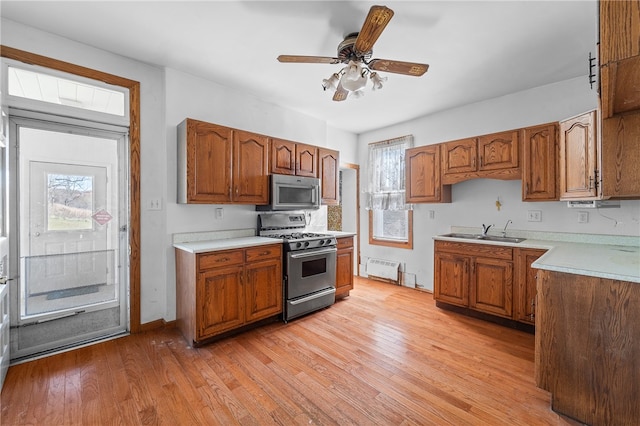 kitchen with appliances with stainless steel finishes, a wealth of natural light, and light wood-type flooring