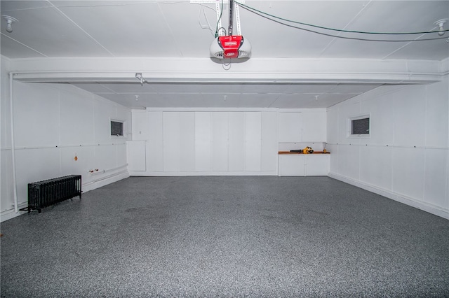 garage with a garage door opener and radiator