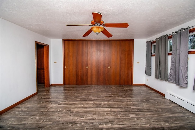 unfurnished room featuring baseboard heating, ceiling fan, dark hardwood / wood-style flooring, and a textured ceiling