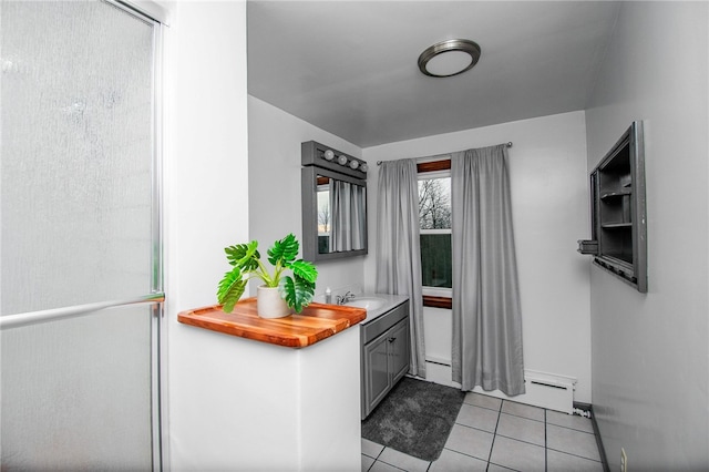 kitchen with gray cabinetry, sink, and light tile patterned floors