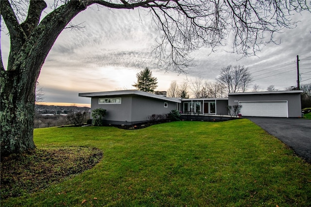 single story home with a garage and a yard