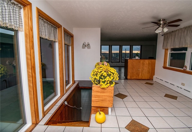 interior space with ceiling fan and baseboard heating