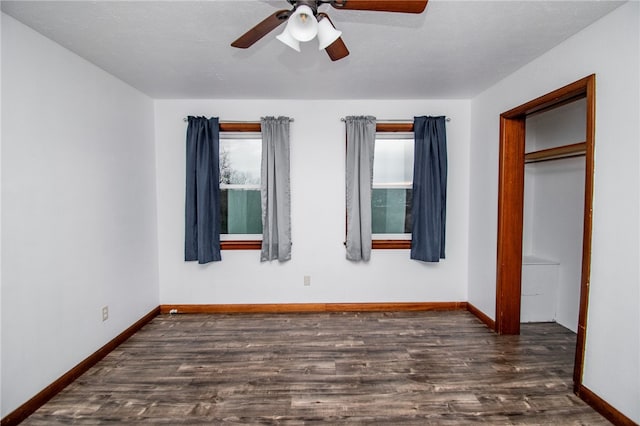 unfurnished bedroom with ceiling fan, a closet, and dark wood-type flooring