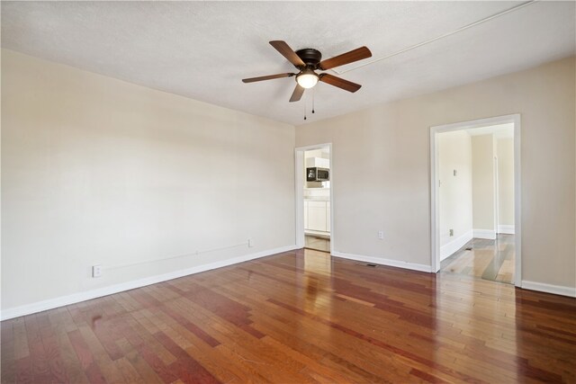 empty room featuring a textured ceiling, hardwood / wood-style flooring, and ceiling fan