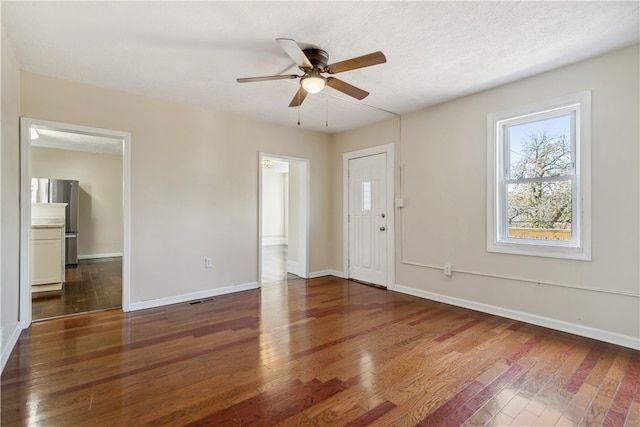 interior space with a textured ceiling, dark hardwood / wood-style flooring, and ceiling fan