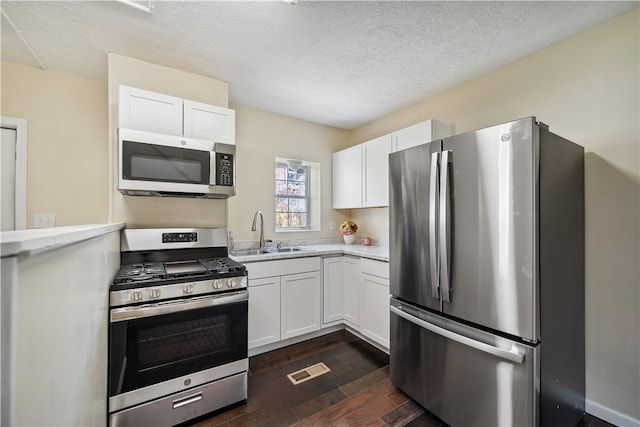 kitchen with white cabinets, appliances with stainless steel finishes, and sink