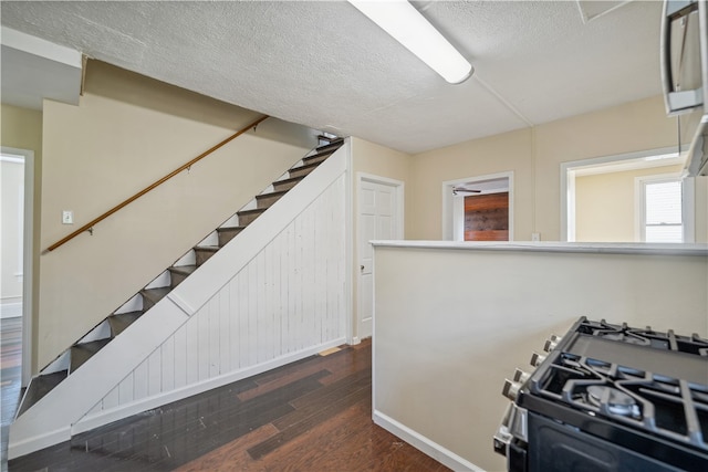 stairway with hardwood / wood-style flooring and a textured ceiling