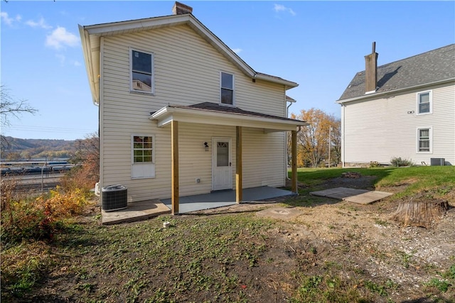 rear view of house with a yard, central AC unit, and a patio area