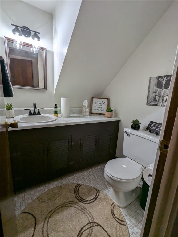 bathroom with vanity, lofted ceiling, and toilet