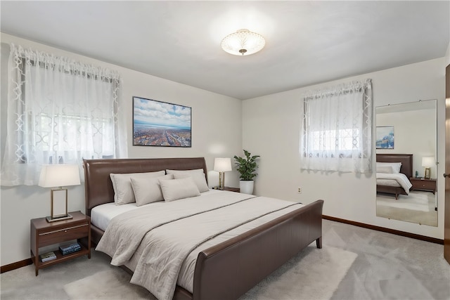 bedroom featuring multiple windows and light colored carpet