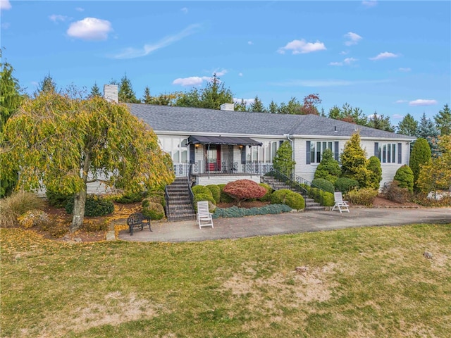 ranch-style house with covered porch and a front yard