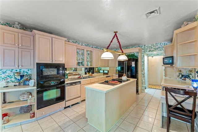 kitchen featuring black appliances, light brown cabinets, and hanging light fixtures