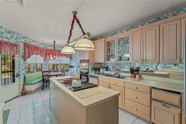 kitchen featuring a kitchen island, light brown cabinets, sink, light tile patterned floors, and appliances with stainless steel finishes