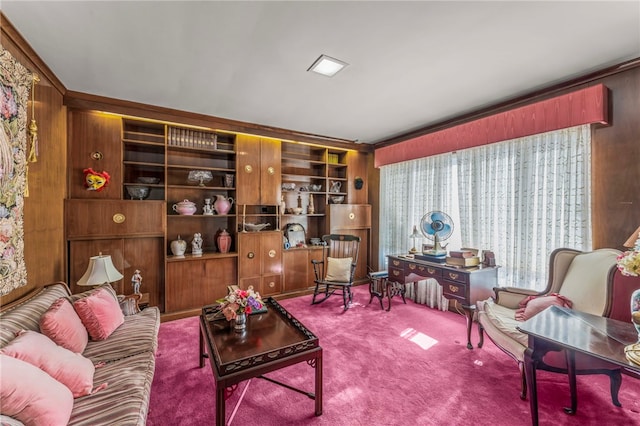 carpeted living room with crown molding, wooden walls, and built in shelves