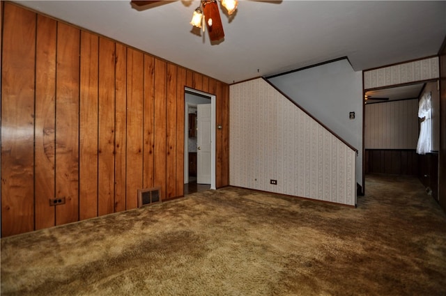 interior space with ceiling fan and wood walls