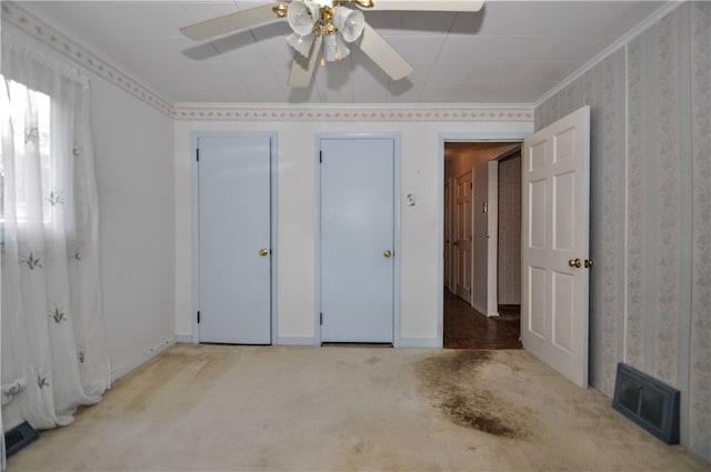 unfurnished bedroom featuring light carpet, crown molding, and ceiling fan