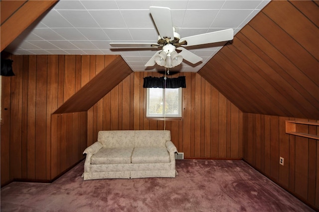 bonus room featuring ceiling fan, wood walls, lofted ceiling, and dark carpet