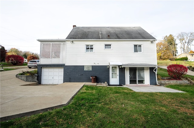 back of house featuring a yard and a garage