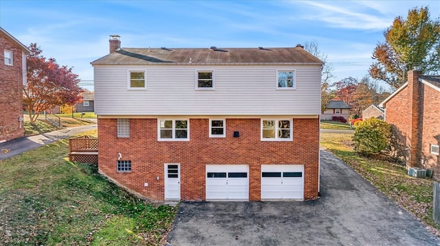 rear view of house featuring central AC and a garage