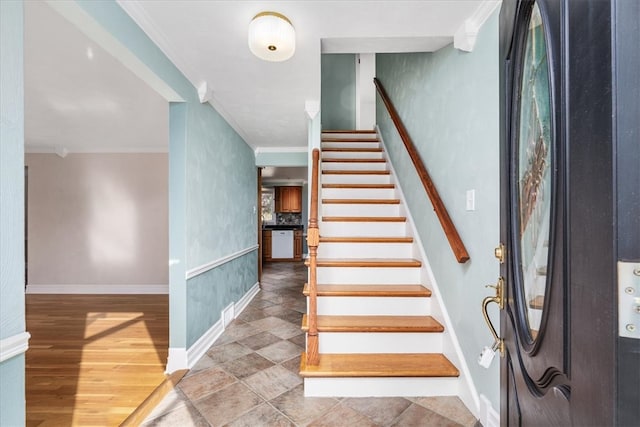 stairs with crown molding and wood-type flooring