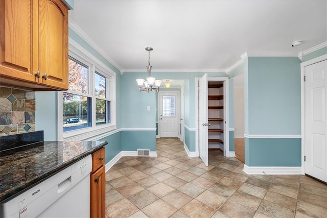 kitchen with crown molding, dark stone countertops, white dishwasher, and pendant lighting